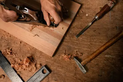 A hand planer taking a shaving off a board on a workbench